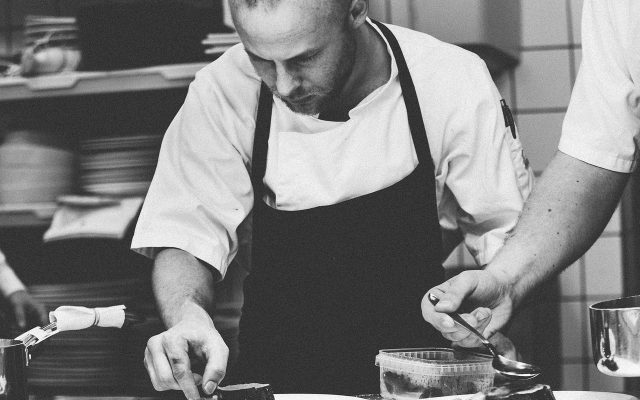 Chefkoch mit Schürze bei der Arbeit in schwarz weiß